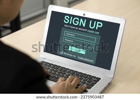 Digital Life Exploration. A focused businessman in black suit engrossed in creating his identity online, registering for an account on his laptop computer.
