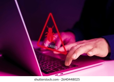 Digital malware warning icon appears on screen while user works on laptop, representing cybersecurity threat, virus attack, hacking risk, and online data breach in modern technology