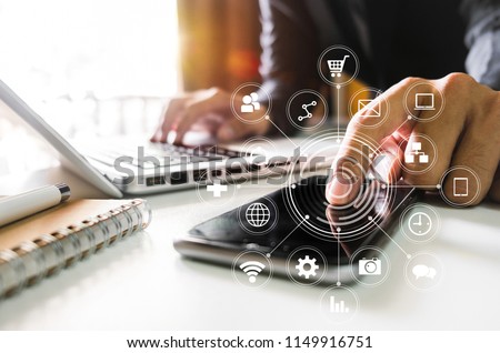 Digital marketing media in virtual screen.businesswoman hand working with mobile phone and modern compute with VR icon diagram at office in morning light 
