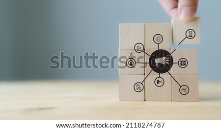 Digital marketing strategy. Marketing technology - MARTECH concept. Data driven for business development  and personalized marketing. Hand puts the wooden cubes with MARTECH icon on grey background.