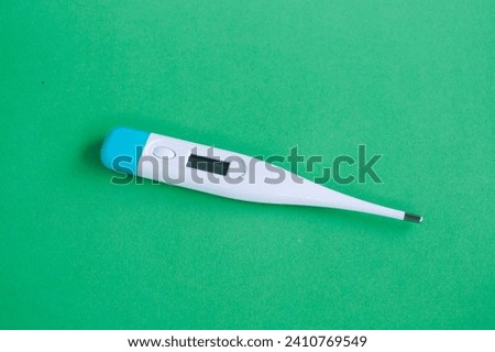 Digital medical thermometer isolated on green