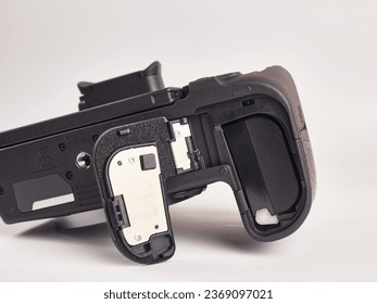 The digital mirrorless camera is shown below with the battery compartment open. Power supply of modern photo equipment.