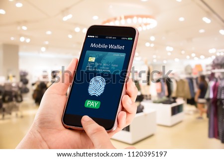 Digital mobile wallet concept.Hands holding mobile phone on blurred fashion store as background