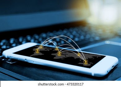 Digital money , bitcoin and network connection concept. smartphone screen with blur laptop background , flare light