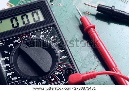 Digital Multimeter Dial and Red Probe on Circuit Board. Concept of electronic repair and diagnostic