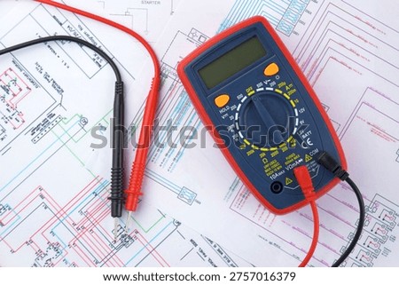 The digital multimeter electrical engineering drawings, circuit breaker and pencils.