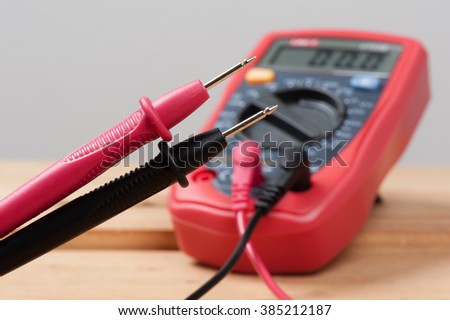 digital multimeter or multitester or Volt-Ohm meter (closeup at test leads), an electronic measuring instrument that combines several measurement functions in one unit.