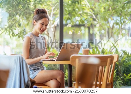 digital nomad millennial gen x lifestyle,asian female freelance casual working from cafe working anywhere work while vacation smiling hand type laptop cheerful positive thinking work remotely in cafe