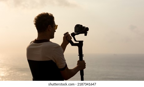 Digital nomad vlogger who shoots travel content with a stabilizer camera that stabilizes for the best landscape shots for blogs and social media. Panning by Travel Videographer with Gimbal Stabilizer