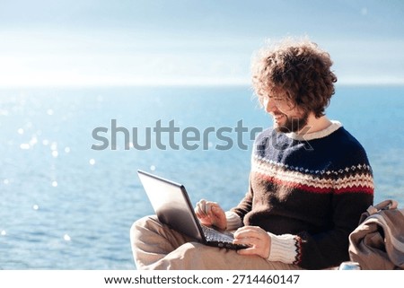 Digital nomad in workation. Freelancer workplace at sea beach. Young man working on vacation outdoors. Happy programmer using laptop in travel at nature. Mindful career minimalism, online education.