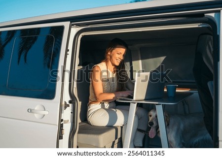 A Digital Nomad Working Remotely Inside a Van While Enjoying Nature with Her Dog