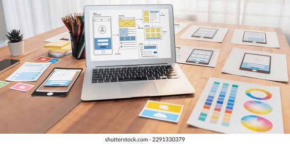 Digital and paper wireframe designs for web or mobile app UI UX display on laptop computer screen. Panoramic shot of developer workspace for brainstorming and design application framework. Scrutinize - Shutterstock ID 2291330379