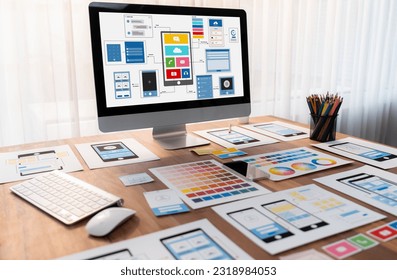 Digital and paper wireframe designs for web or mobile app UI UX display on laptop computer screen. Panoramic shot of developer workspace for brainstorming and design application framework. Scrutinize - Shutterstock ID 2318984053