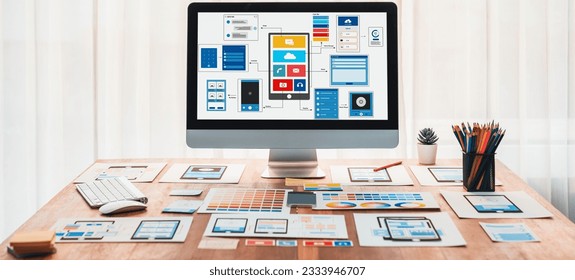 Digital and paper wireframe designs for web or mobile app UI UX display on laptop computer screen. Panoramic shot of developer workspace for brainstorming and design application framework. Scrutinize - Shutterstock ID 2333946707