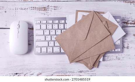 Digital and Physical Mail: Computer Keyboard, Mouse, and Stacked Paper Envelopes