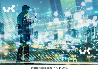 Digital revolution and Internet of Things concept. Double exposure of night city light and silhouette of business man standing and using smart phone with futuristic connection icons. - Shutterstock ID 477140941