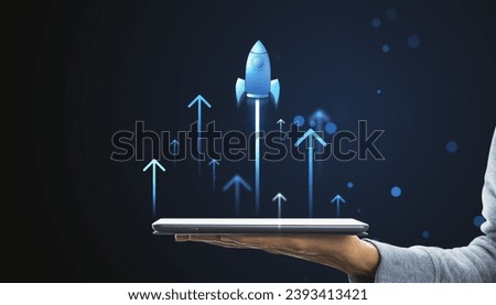 Digital rocket launching from tablet on hand. Online startup and progress concept