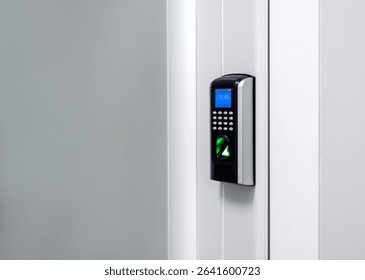 Digital screen with finger scanner and passcode panel, modern door access control on white wall at the entrance door with copy space. Fingerprint scan, security concept.