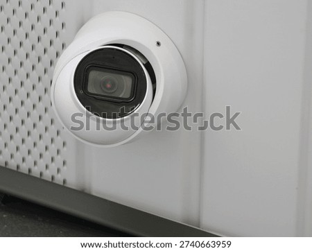 Digital security camera attached to outdoor siding