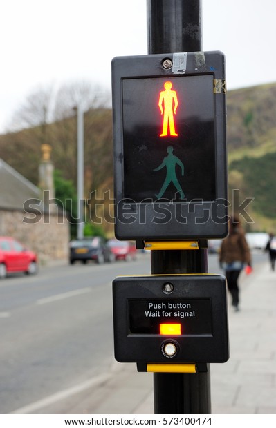 Digital sign for crossing the road shows red color icon\
over the green icon that means don\'t cross the road until green\
light pop up 