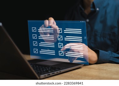 Digital smart checklist and business management on virtual screen concept, Businessman use laptop and use a pen marking on checklist paperless office and document management and future business 