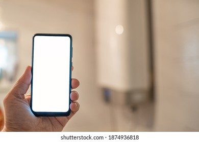 digital smart phone in hand on the blur background of water boiler