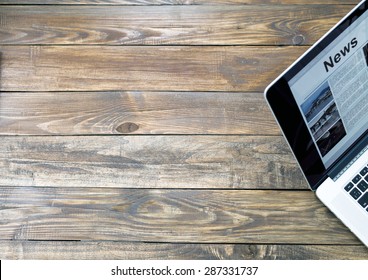 Digital Subscription On Rough Wooden Desk Concept.
Handcrafted Natural Wooden Texture Table With Large Copy Space And Cropped Laptop With World News Page On Screen