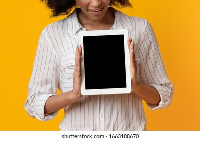 Digital Tablet With Blank Black Screen In Hands Of Unrecognizable Afro Woman Over Yellow Background, Cropped Image, Free Space