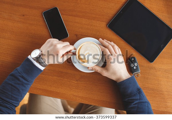 Digital
tablet with blank screen in coffee shop cafe. Man's hands with
coffee cup. car keys, smartphone and digital tablet computer.
business, education, people and technology.
