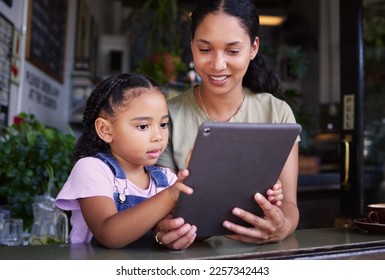 Digital tablet, coffee shop and mother with her child reading the online menu before ordering. Technology, internet and mom on a date with her girl kid with a touchscreen mobile device in a cafe. - Powered by Shutterstock