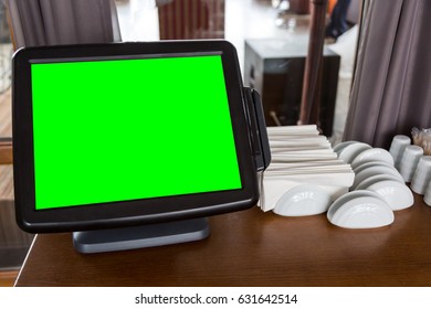 Digital tablet computer green screen in a cafe on the table.