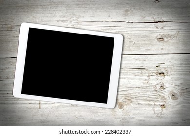 Digital tablet computer with isolated screen on old wooden desk