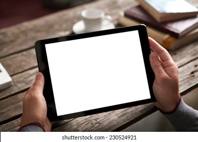 Digital tablet computer with isolated screen in male hands over cafe background - table, cup of coffee...