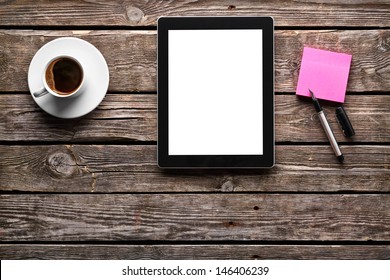 Digital tablet computer with sticky note paper and cup of coffee on old wooden desk. Simple workspace or coffee break with web surfing. - Powered by Shutterstock