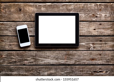 Digital Tablet Computer And White Smart Phone With Isolated Screens On Old Wooden Desk.