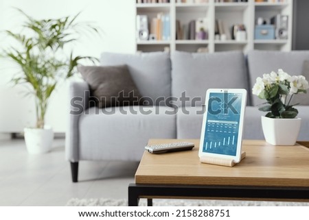 Digital tablet displaying weather forecast on the living room table