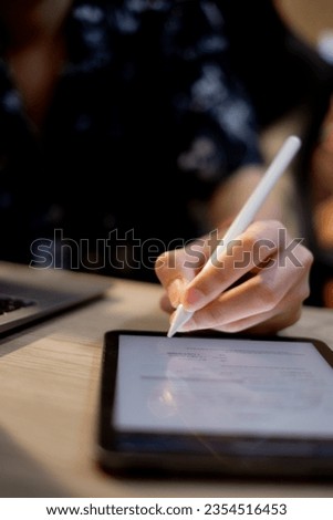 With a digital tablet in hand, a businessman confidently finalizes a deal, underlining the importance of electronic signatures and online agreements in today's professional landscape.
