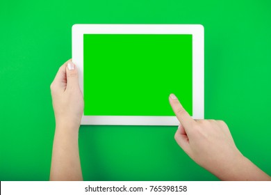 Digital Tablet and Hands on green Background. Finger shows something on empty screen