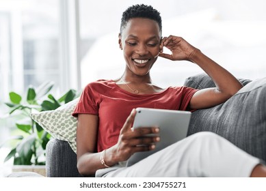 Digital tablet, happy and black woman relax on a sofa for social media, reading and browsing blog in her home. Smile, online and African female person on couch with ebook, streaming or subscription - Powered by Shutterstock