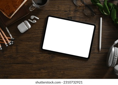 Digital tablet, headphone and stationery on wooden table. Blank screen for your advertising text message - Shutterstock ID 2310732921