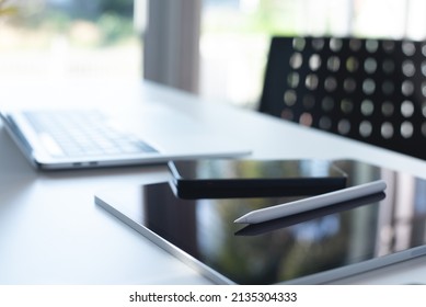 Digital Tablet, Mobile Smart Phone And Laptop Computer On White Office Table In Meeting Room With No People, Computer Devices And Blurred Background. Business And Paperless Office Concept.