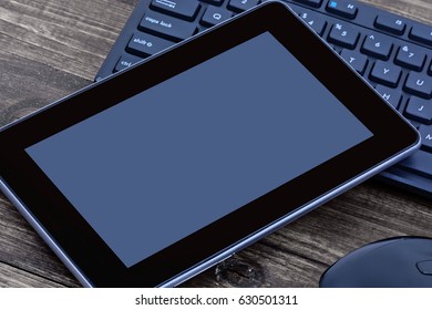 Digital tablet with mouse and computer keyboard on table