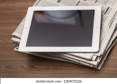 Digital Tablet On Newspaper Concept For Internet And Electronic News