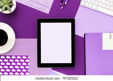 Digital Tablet On Office Desk In Purple Color. Flat Lay.