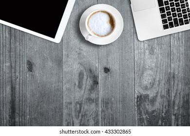digital tablet pc, computer and cup of coffee on wooden table