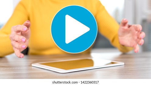 Digital tablet with play concept between hands of a woman in background