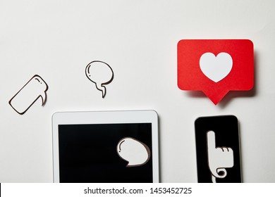 digital tablet and smartphone with paper thought and speech bubbles, paper heart, pointing card on white surface - Shutterstock ID 1453452725