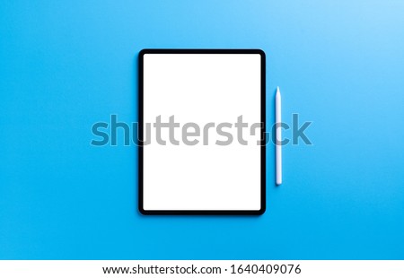 digital tablet and stylus pen on light blue background