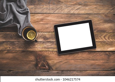 Digital tablet and a tea cup on wooden table. Flat lay.  - Powered by Shutterstock