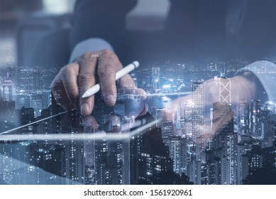 Digital technology, software development, internet network connection, marketing plan. Double exposure of business man working on digital tablet computer and buildings in smart city, blue tone
